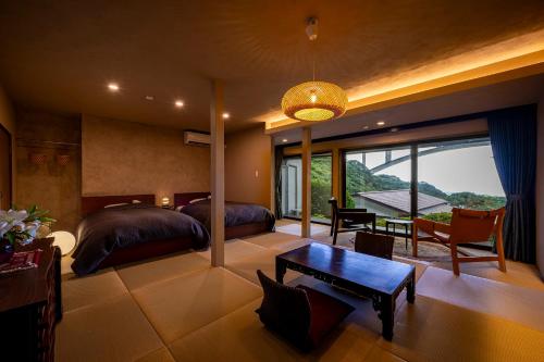 a bedroom with two beds and a table at Okamotoya in Beppu