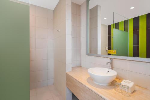 a bathroom with a sink and a mirror at Ibis Styles Malang in Malang