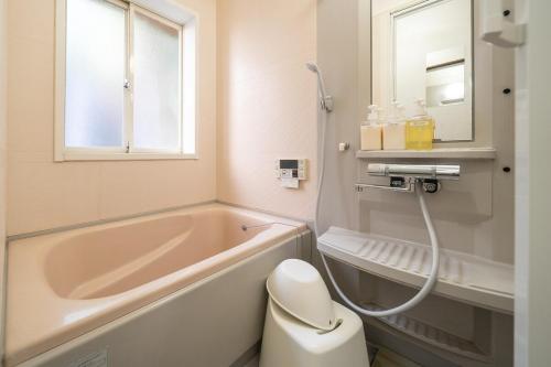 ein Badezimmer mit Badewanne, Toilette und Waschbecken in der Unterkunft R-house 6th in Atami