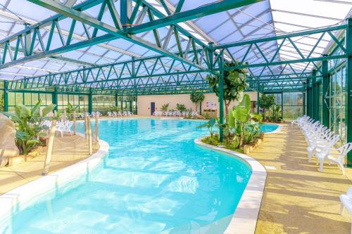 a pool in a building with chairs and a swimming pool at Camping Le Parc de Paris in Villevaudé