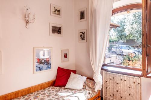 une chambre avec une fenêtre et un lit avec des oreillers rouges dans l'établissement Villa Luce, à Porto Santo Stefano