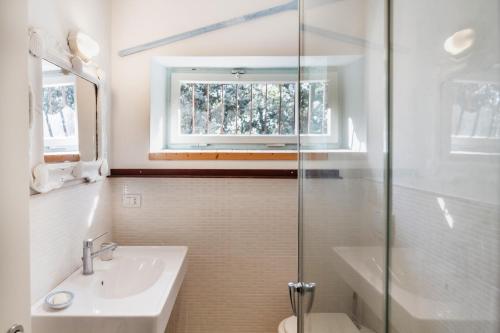une salle de bain avec un lavabo et des toilettes et une fenêtre dans l'établissement Villa Luce, à Porto Santo Stefano