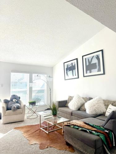 a living room with a couch and a table at Luxe, Family Friendly, Spacious & Private Entrance in Addison