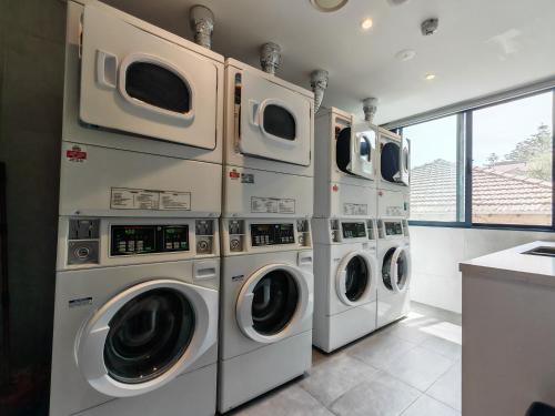 a row of washing machines in a laundry room at Studio in heart of Roseville in Sydney
