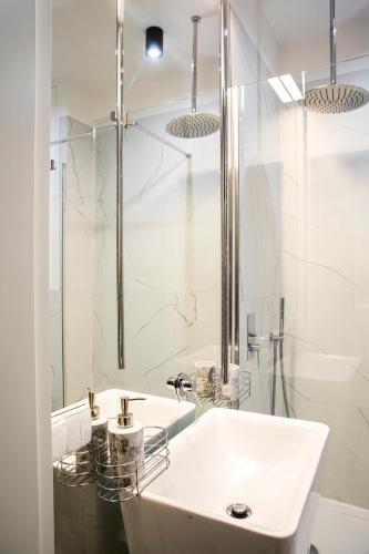 Un baño blanco con lavabo y ducha en Maya's Flats & Resorts 44 - 3 Rooms Apartment On C, en Gdansk
