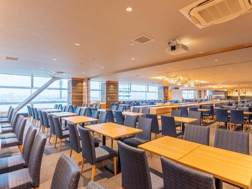 an empty dining room with tables and chairs at LiVEMAX Sakishima Cosmo Tower Hotel in Osaka