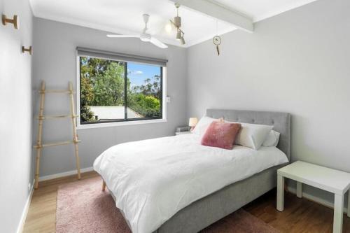 a white bedroom with a bed and a window at Lakeview Retreat Bonnie Doon - Sleeps 12 in Bonnie Doon