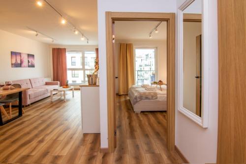 - un salon avec un lit et un canapé dans l'établissement Maya's Flats & Resorts 48 - Szafarnia, à Gdańsk