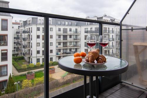 - une table avec un bol de pain et deux verres de vin dans l'établissement Maya's Flats & Resorts 48 - Szafarnia, à Gdańsk