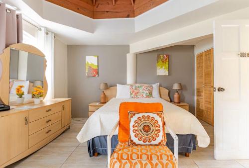 a bedroom with a large bed and a chair at Seacastles by the beach/pool in Montego Bay