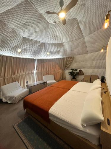 a bedroom with a large bed in a tent at glamping base YOLO in Nakijin