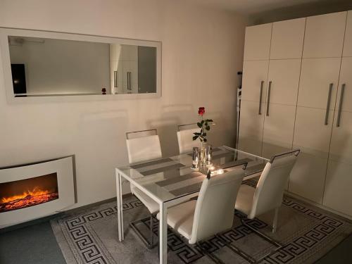 a dining room with a glass table and chairs and a fireplace at Skipper am Steinhuder Meer in Steinhude