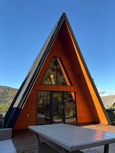 a triangular house with a table in front of it at Macko’s cabin in Băile Tuşnad