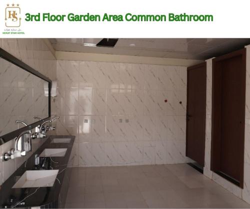 a bathroom with two sinks and a mirror at Herat Star Hotel in Herāt