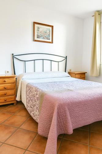 a bedroom with a bed with a pink blanket on it at Edelweiss con WIFI y parking in Sierra Nevada