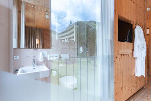 a bathroom with a sink and a toilet at Alpenhotel Ammerwald in Reutte
