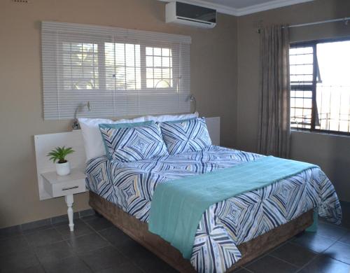 a bedroom with a bed with a blue and white comforter at Natspat 20 in Margate