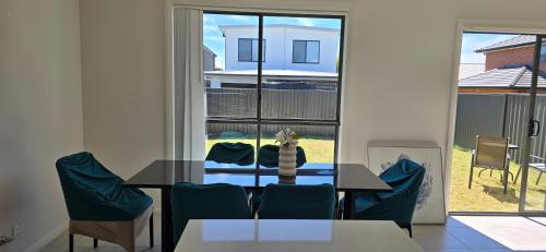 a dining room with a table and blue chairs at Luxurious new 5 bedroom house and Double garage in Marsden Park
