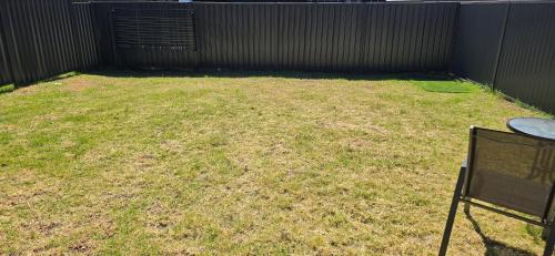 a yard with some grass and a fence at Luxurious new 5 bedroom house and Double garage in Marsden Park