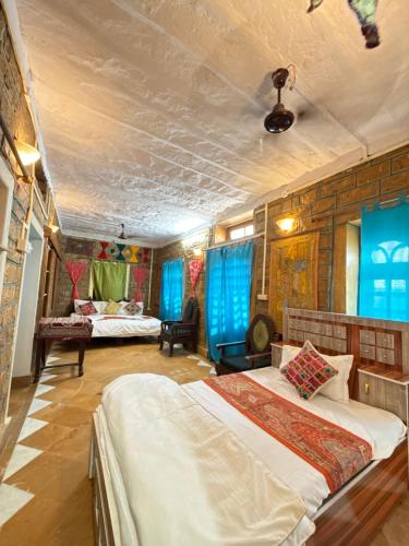 Un dormitorio con dos camas en una habitación con ventanas azules. en Hostel Francesco's Jaisalmer, en Jaisalmer