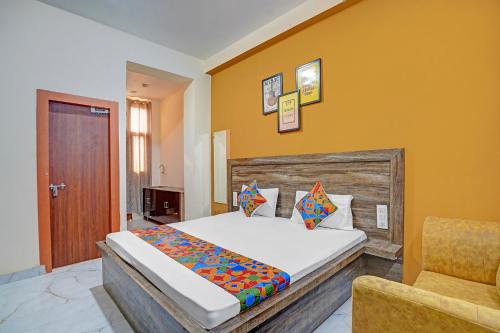 a bedroom with a bed and a chair at FabHotel Galaxy Greno Celebration in Greater Noida