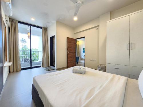 a bedroom with a large bed and a large window at Peaceful Candolim 2BHK Apartment - Family Stay, Scenic View, Pool in Candolim