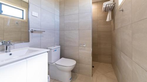 a bathroom with a toilet and a sink and a mirror at 1770 Eco Resort in Agnes Water