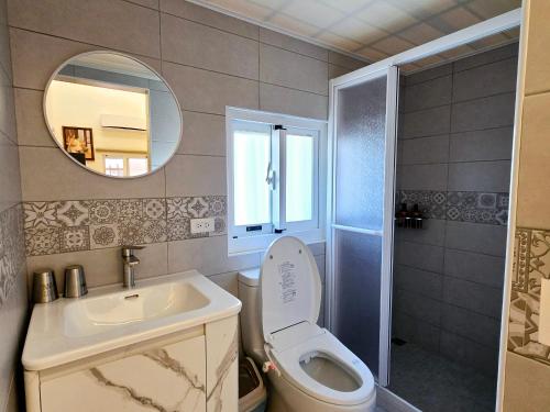 a bathroom with a toilet and a sink and a mirror at Yaboju BnB in Huxi