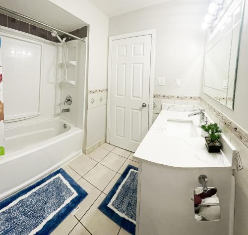 a white bathroom with a tub and a sink at Full Privacy Apartment with Free Parkrings in Toronto