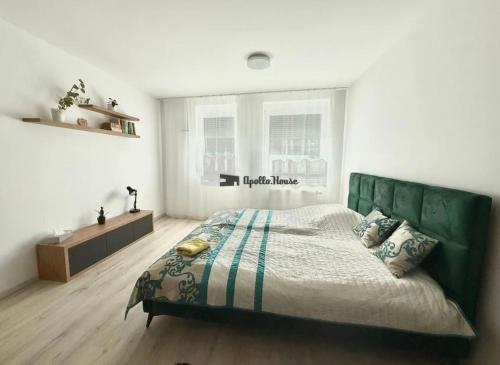 TrnávkaにあるÚtulný apartmán Nuppuの白い部屋に緑のベッドが備わるベッドルーム1室