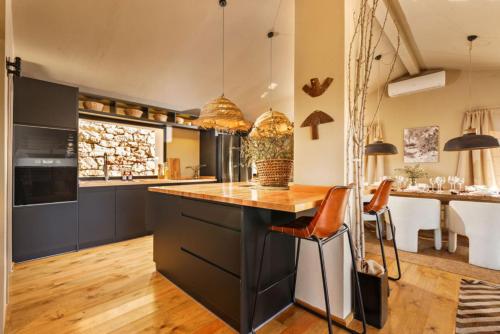 a kitchen with a black island with a wooden counter top at Discreet Luxury Home With Splendid Views in La Cimada