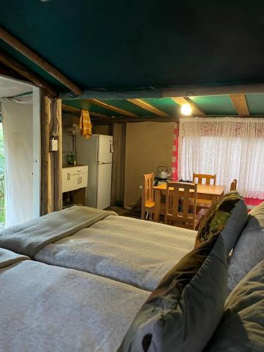 a large bed in a room with a table at Hindthausen in Knysna