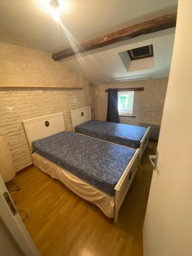 a bedroom with two beds in a room at Charmante Maison dans village calme in Chef-Boutonne