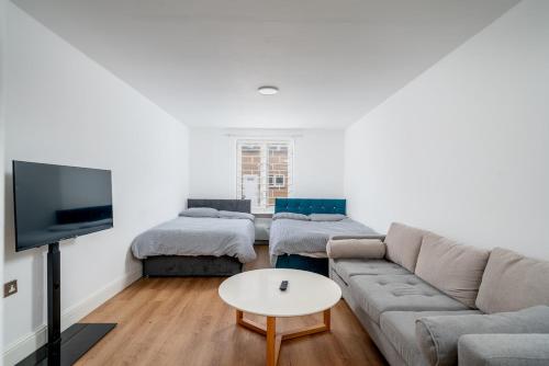 a living room with a couch and a tv at 16 Guests, 4 Studios, Groups, Contractors, Stockwell SW9 in London