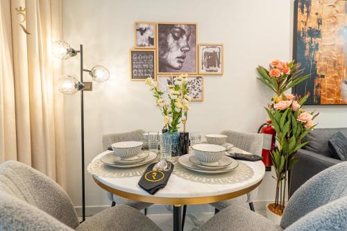 a living room with a table with chairs and a couch at Elegant 1BR Escape - Chic Al Maryah Cozy Retreat in Abu Dhabi