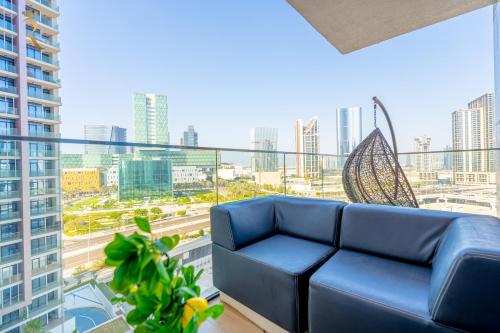 a blue couch on a balcony with a view of a city at Elegant 1BR Escape - Chic Al Maryah Cozy Retreat in Abu Dhabi