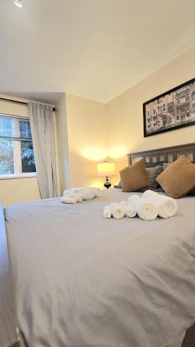 a bedroom with a large white bed with towels on it at Spacious & Cozy House Near Lonsdale, Peaceful North Vancouver Stay in North Vancouver