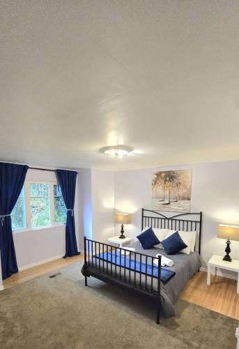 a bedroom with a bed with blue pillows at Spacious & Cozy House Near Lonsdale, Peaceful North Vancouver Stay in North Vancouver