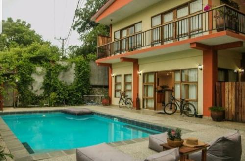 a swimming pool in front of a house at Teala Villa in Mantaak