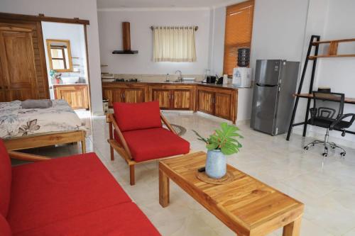 a living room with a red chair and a kitchen at Teala Villa in Mantaak