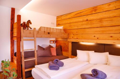 a bedroom with two bunk beds with purple towels at Hotel Forsthof in Sankt Johann im Pongau