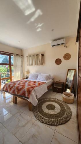 a bedroom with a large bed and a rug on the floor at Teala Villa in Mantaak