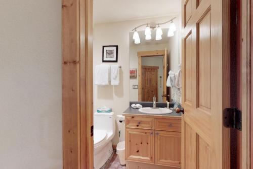 ein Badezimmer mit Waschbecken, Toilette und Spiegel in der Unterkunft Tenderfoot Lodge 2605 in Snake River Health Services Incorporated Heliport