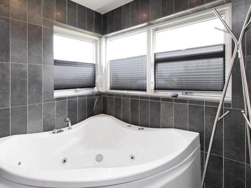 a bath tub in a bathroom with two windows at 10 person holiday home in Brovst-By Traum in Brovst