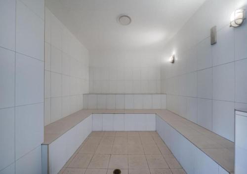 a white room with a bench and a light at Studio Lagoon Apartment in Salamander Bay