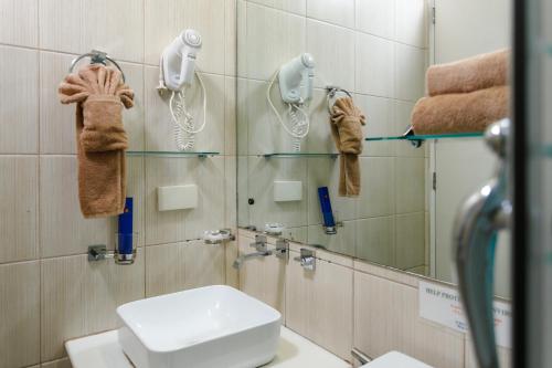 a bathroom with a toilet and a mirror and towels at LivStudios Manila Bay in Manila