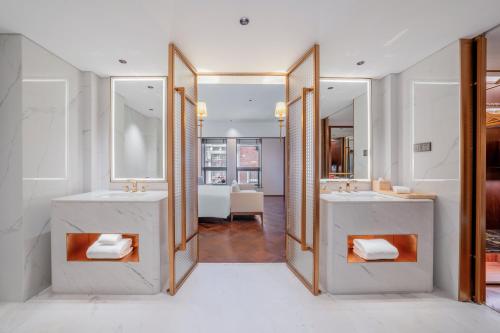 une salle de bain avec deux lavabos et deux miroirs dans l'établissement Wyndham Beijing North, à Changping
