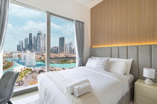 a bedroom with a bed and a large window at The Grande Signature Experience Modern 2BR with Incredible Views of Burj Khalifa & Dubai Fountain, Steps Away from Dubai Mall in Dubai