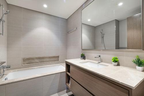 a bathroom with a tub and a sink and a bath tub at The Grande Signature Experience Modern 2BR with Incredible Views of Burj Khalifa & Dubai Fountain, Steps Away from Dubai Mall in Dubai
