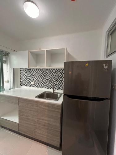 a kitchen with a stainless steel refrigerator and a sink at Vibe Old Town 452 in Phuket